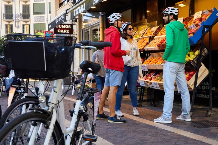 a group of people standing next to a bicycle