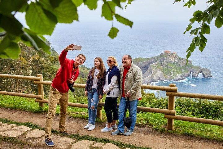 a group of people standing next to a body of water