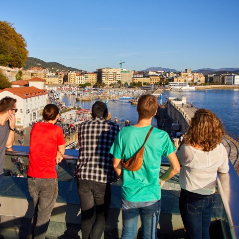 a group of people standing next to a body of water